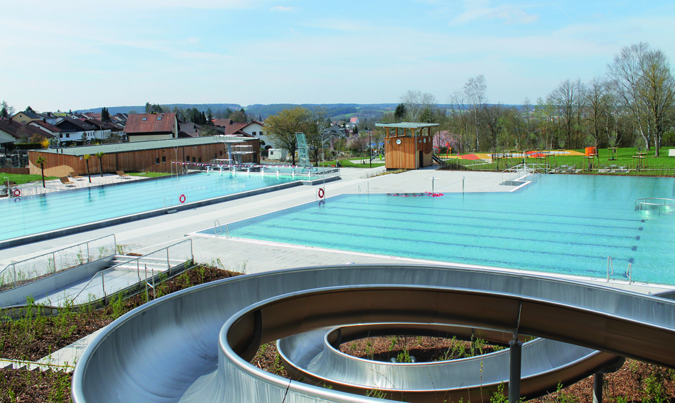 Blick auf das Freibad mit Rutsche und Schwimmbecken.